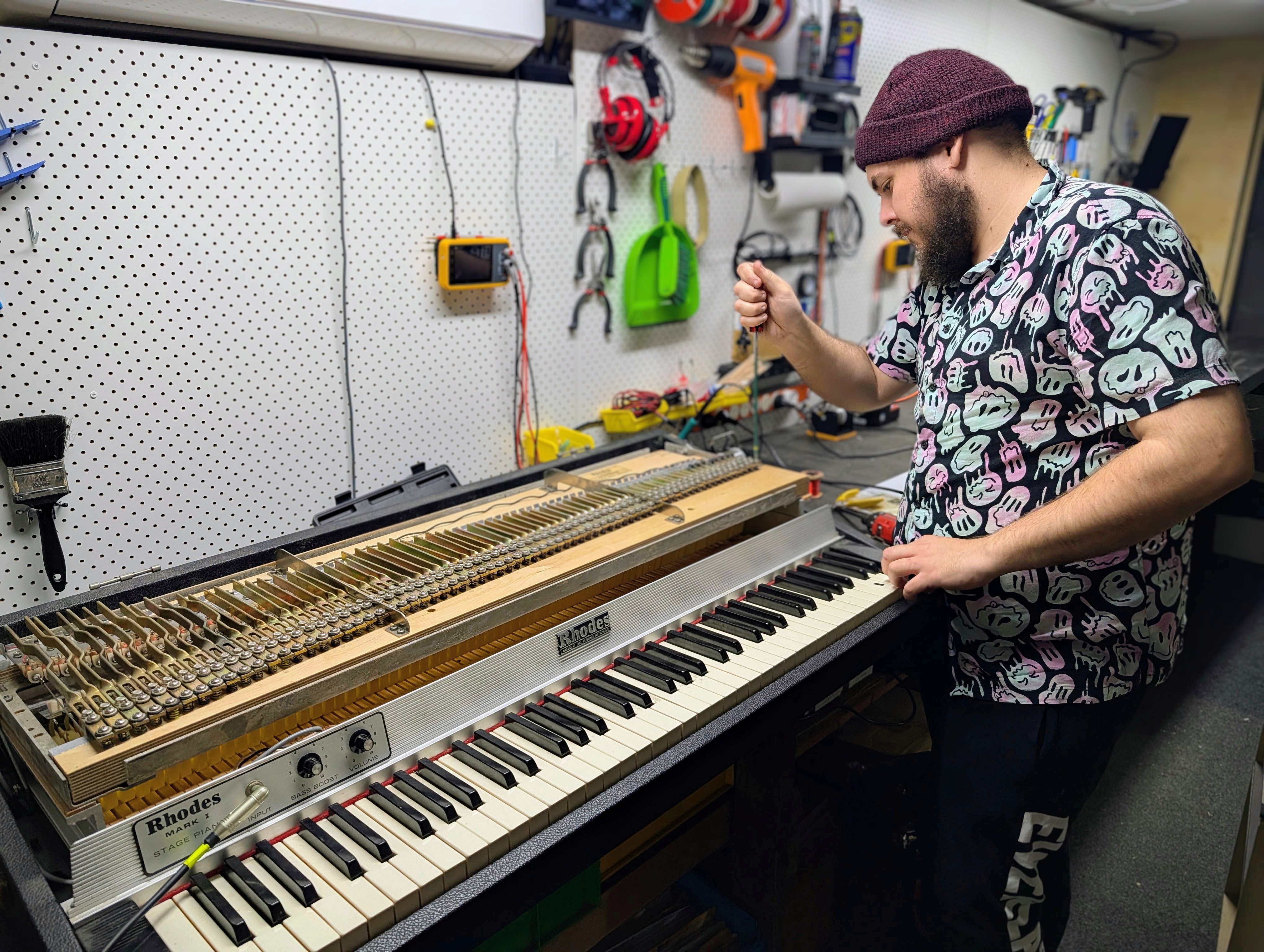 Photo of a technician working on an electric piano in a workshop